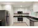 Modern kitchen with white cabinets, stainless steel appliances, and black countertops at 2413 Hillside Ave, Decatur, GA 30032