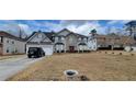 Charming two-story house with a well-manicured lawn, a two car garage, and an attractive stone facade entryway at 2453 Wall Se St, Conyers, GA 30013