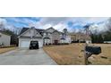Charming two-story house with a well-manicured lawn, a two car garage, and an attractive stone facade entryway at 2453 Wall Se St, Conyers, GA 30013