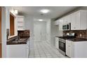 Updated kitchen featuring white cabinets, stainless steel appliances, and tile flooring at 285 Belmont Trl, Covington, GA 30016