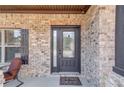 Inviting front entry features a modern door, brick facade, and a cozy welcome mat at 1217 Trophy Club Ave, Dacula, GA 30019