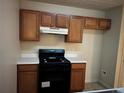 Kitchen with wood cabinets, laminate countertops, black appliances including range and vent hood at 4620 Grand Central Pkwy, Decatur, GA 30035