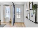 Bright entryway with hardwood floors, barn door, decorative shelves, and a view to the outside at 224 Village Overlook # K3, Canton, GA 30114