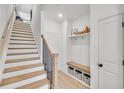 Modern staircase with wood treads, a dark metal railing, and a built-in bench with storage cubbies at 224 Village Overlook # K3, Canton, GA 30114