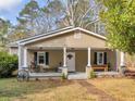 Inviting front porch with classic columns, offering a relaxing outdoor space with benches and decor at 583 Mount Zion Rd, Oxford, GA 30054