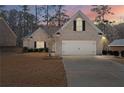 Charming single-story brick home with a two-car garage and well-maintained lawn at twilight at 106 Saint Margrit Cir, Stockbridge, GA 30281