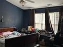 Primary bedroom with dark blue walls, natural light, and wood-frame bed; curtains over the windows at 430 Parkway Rd, Union City, GA 30291