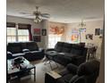 Cozy living room featuring a ceiling fan, neutral walls, and dark couches plus natural lighting at 430 Parkway Rd, Union City, GA 30291