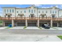 Back of townhomes with garages, wooden decks, and well-manicured lawns at 2380 Elgar Park Pl # 101, Duluth, GA 30096