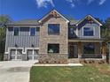 Charming two-story home with a stone and gray brick facade and a two-car garage at 3687 Thornhill Ct, Douglasville, GA 30135