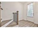 Bright hallway with stylish wood-look flooring and modern staircase with white walls at 4360 Sims Park Overlook, Suwanee, GA 30024