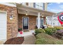 Inviting front porch featuring stone accents, manicured shrubs, and an elegant front door at 6371 Pierless Ave, Sugar Hill, GA 30518