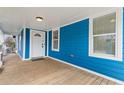 Charming covered front porch with wood flooring, blue siding and a white front door at 1598 Jonesboro Se Rd, Atlanta, GA 30315