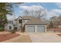 Inviting home with stone accents, a two-car garage, and a well-manicured front yard at 10640 Branham Fields Rd, Johns Creek, GA 30097