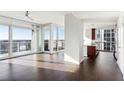 Open floor plan with hardwood floors, large windows leading to balcony, and view of the kitchen at 3325 Piedmont Ne Rd # 1502, Atlanta, GA 30326
