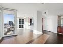 Bright living room with hardwood floors, floor-to-ceiling windows, city views, and open access to kitchen at 3325 Piedmont Ne Rd # 1502, Atlanta, GA 30326