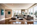Bright living room with a large sectional sofa, hardwood floors, and oversized windows with outdoor views at 362 Old Ivy Ne Rd, Atlanta, GA 30342