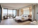 A luxurious bedroom featuring a balcony with views, modern decor, a sitting area, and an adjoining bathroom at 362 Old Ivy Ne Rd, Atlanta, GA 30342