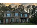 Well-maintained two-story brick and stone home with symmetrical windows and a covered front porch at 2304 Northglenn Ct, Conyers, GA 30013