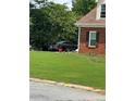 A black sporty car is parked on the lawn next to a two-story brick home at 3305 Wolverton Sw Ct, Conyers, GA 30094