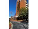 Exterior shot of the brick condo building with trees, lawn, and a blacktop drive at 300 Johnson Ferry Ne Rd # B401, Atlanta, GA 30328