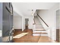 Bright foyer showcasing hardwood floors and a staircase with wooden handrail at 1903 Olde Village Run, Dunwoody, GA 30338