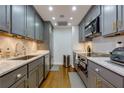 Galley kitchen features gray cabinets, stainless steel appliances, and granite countertops at 145 15Th Ne St # 1012, Atlanta, GA 30309