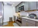 Well-lit kitchen boasts gray cabinetry, stainless appliances, and a white subway tile backsplash at 145 15Th Ne St # 1012, Atlanta, GA 30309
