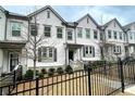 Charming exterior view of townhome with iron fence, trimmed bushes and neutral paint at 353 Vista Ln, Woodstock, GA 30189