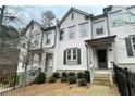Exterior view of a two-story townhome featuring a gray front door and manicured landscaping at 353 Vista Ln, Woodstock, GA 30189