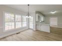 Bright dining room featuring hardwood floors, a modern chandelier, and backyard views at 2541 Berwick Walk, Snellville, GA 30078