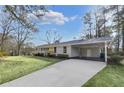 View of the home's front yard, carport, and driveway, showcasing a well-maintained landscape at 1963 Shepherd Sw Cir, Atlanta, GA 30311