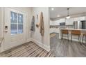 Bright entryway with a view into the open kitchen, featuring white cabinets and stainless steel appliances at 259 Vista Ln, Woodstock, GA 30189