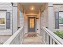 Inviting front porch with gray door, brick accents, and a welcoming 