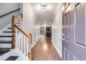 Inviting entryway with hardwood floors, staircase, and view into living room with fireplace at 3349 Thornbridge Dr, Powder Springs, GA 30127