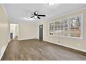 Bright living room featuring wood-look floors, a ceiling fan, and large window with views at 1729 James Burgess Rd, Suwanee, GA 30024