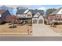 Inviting two-story home with a stone and gray siding exterior and an attached two-car garage at 3360 Gables Ct, Cumming, GA 30041