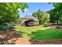 Large grassy backyard with a screened-in porch and mature trees at 7215 Gresham Trce, Cumming, GA 30040