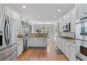 Bright kitchen featuring stainless steel appliances, granite counters, and wood floors at 7215 Gresham Trce, Cumming, GA 30040