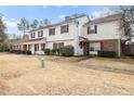 Two story home with light exterior paint, red shutters, covered porch, and sparse landscaping at 2613 Stratford Ln, Morrow, GA 30260