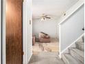 Cozy living room with neutral walls, ceiling fan, and carpeted stairs at 2613 Stratford Ln, Morrow, GA 30260