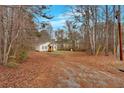 One-story home with a cozy front porch, set back from the road and surrounded by mature trees at 80 Holder St, Temple, GA 30179