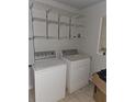 Practical laundry room with a washer, dryer, and shelving for storage at 2305 Phillips Rd, Lithonia, GA 30058