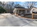 Charming home featuring a cozy porch with rocking chairs, with a newly paved concrete driveway at 100 Reed St, Canton, GA 30114