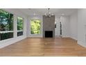 Bright living room featuring hardwood floors, fireplace, and multiple windows with verdant backyard views at 1186B Francis Nw St, Atlanta, GA 30318