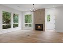 Cozy living room with a fireplace, hardwood floors, natural light, and a stylish chandelier at 1186B Francis Nw St, Atlanta, GA 30318