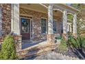 Inviting front porch with stone accents and an elegant entrance at 4050 Preserve Crossing Ln, Cumming, GA 30040