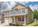 Side view of a brick home with two-car garage, landscaped garden, and neutral siding at 920 Sublime Trl, Canton, GA 30114