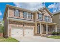 Front exterior showing brick facade, two-car garage, covered entryway, and manicured lawn at 920 Sublime Trl, Canton, GA 30114