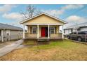 Attractive yellow home with a bright red door and a neatly kept front lawn at 718 Dalvigney Nw St, Atlanta, GA 30318